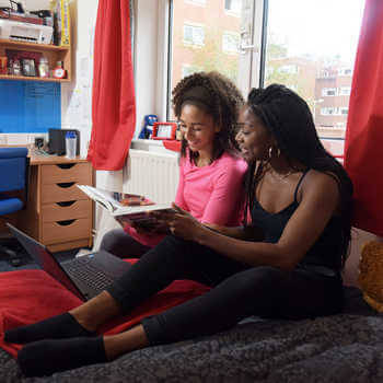 Two Ƶ students sitting on bed in halls
